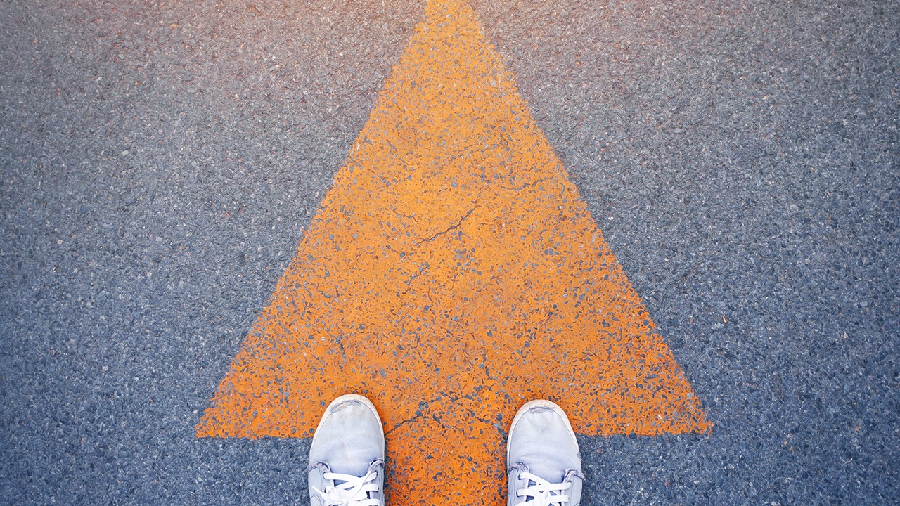 person-looking-down-on-road-with-arrow-pointing-up